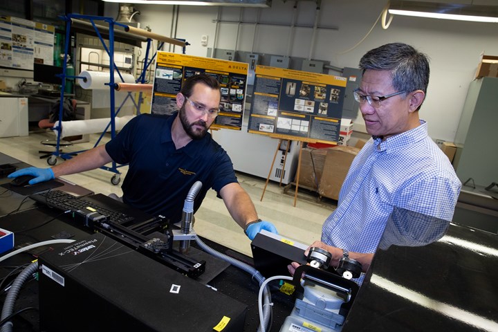 Chuck Zhang working with someone in a lab 